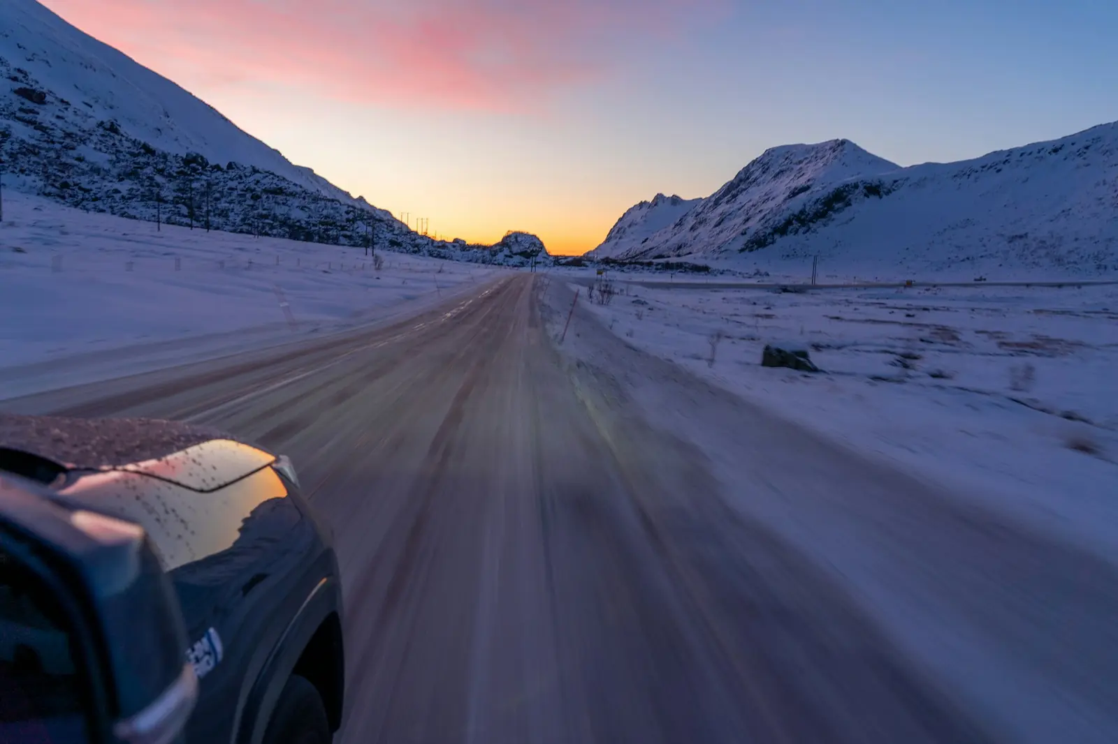 En bil på snötäckt väg i Lofoten