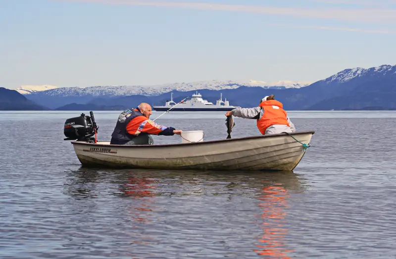 Fritidsfiskare med spö och fångst i en liten båt vid Tysnes