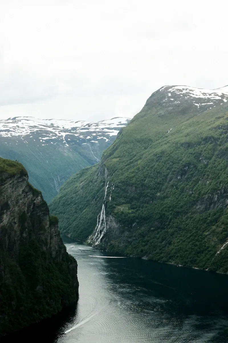 Geirangerfjorden med branta gröna fjäll och vattenfall