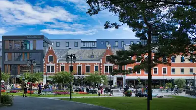 Torget i Kristiansand med uteserveringar och människor i sommarljus