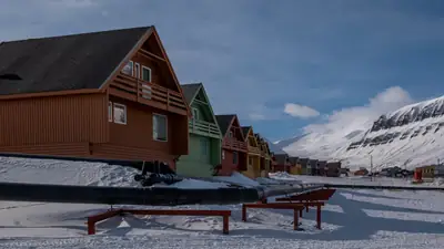 Färgglada hus och snötäckta fjäll i Longyearbyen på Svalbard