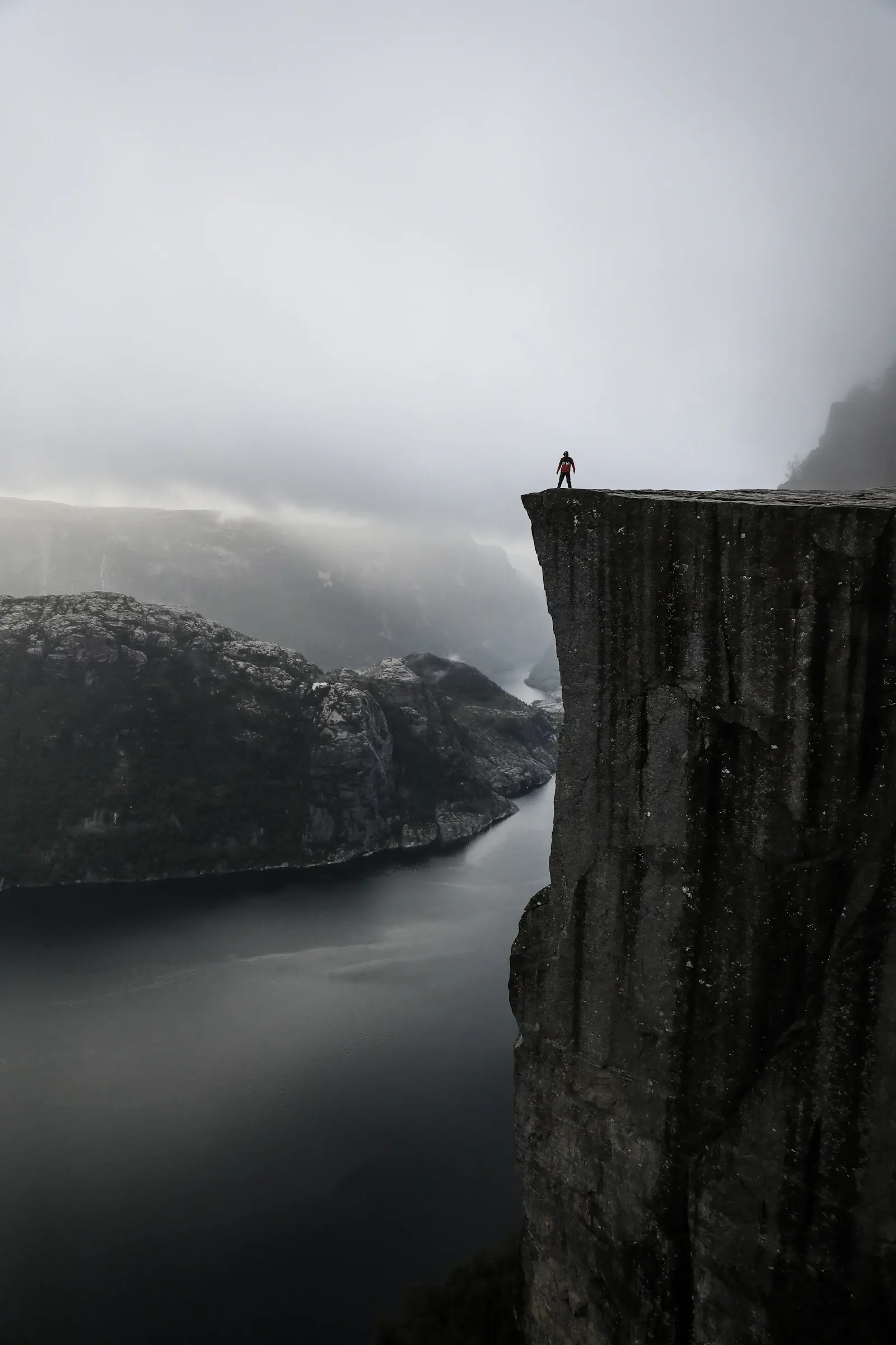 Preikestolens klippavsats över Lysefjorden i dimmigt väder