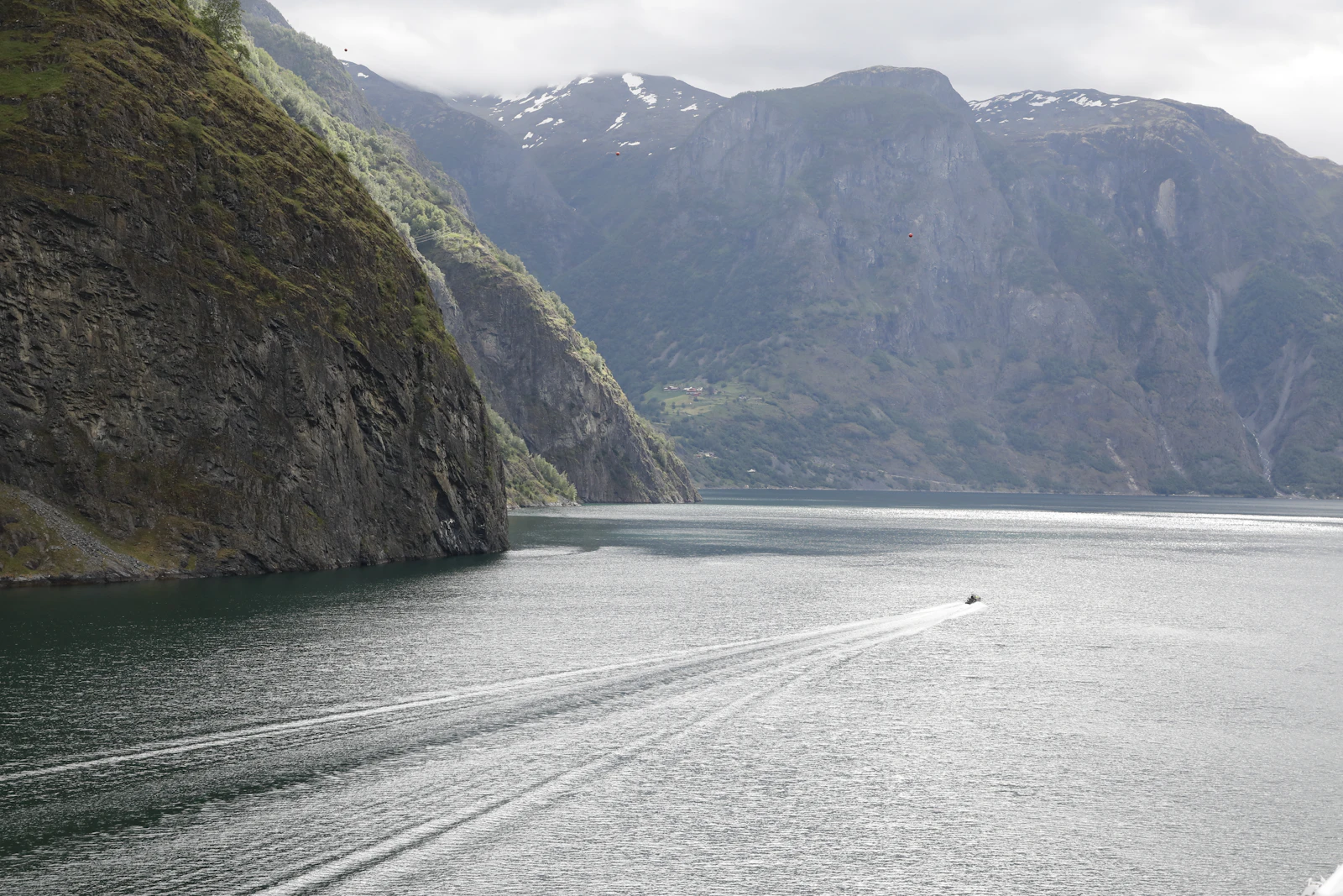 En båt på Sognefjorden mellan branta fjällsidor